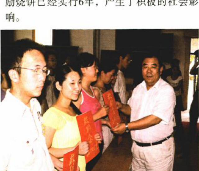 一张多人合影照片，中间的人手里拿着红色标语或证书