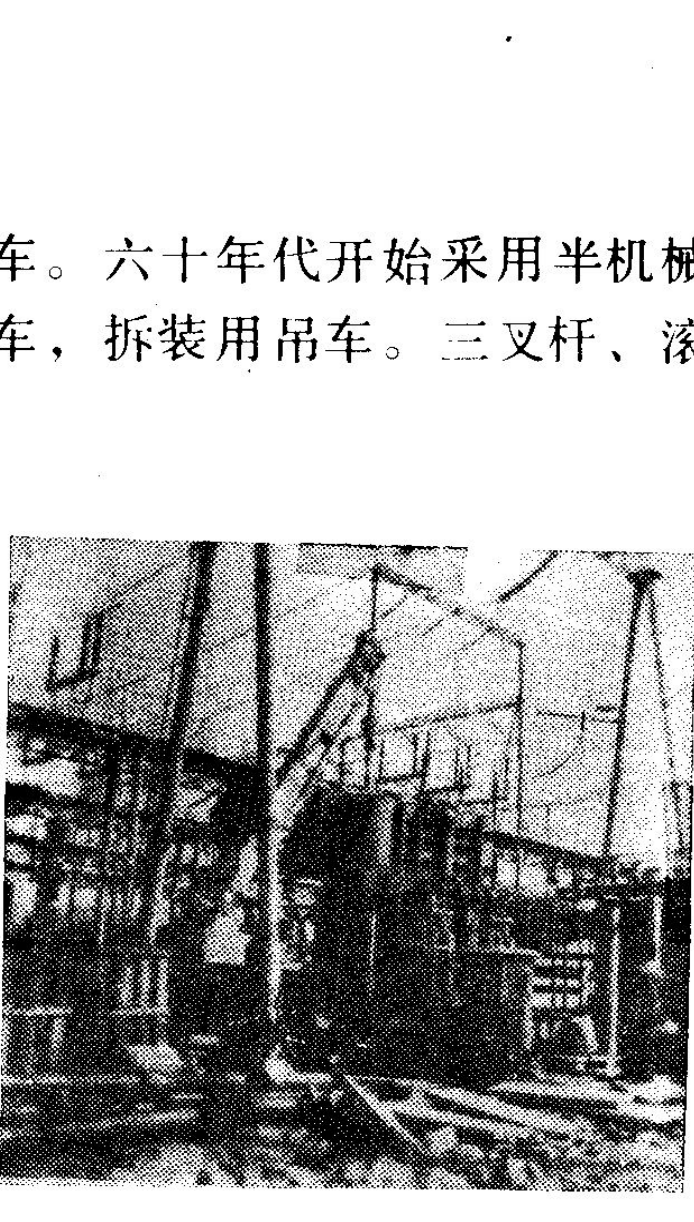 一张黑白历史照片，展示工业建筑或施工现场的塔架与电线杆结构。